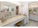 Light-filled bathroom featuring a vanity with a makeup area and a mirrored wall at 6650 Schooner Bay Cir # 6650, Sarasota, FL 34231