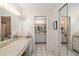 Hall bathroom showcasing a vanity with a makeup area, mirrored wall, and tiled flooring at 6650 Schooner Bay Cir # 6650, Sarasota, FL 34231
