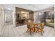 Dining area with a mirrored wall reflecting the kitchen, complemented by a glass table and patterned chairs at 6650 Schooner Bay Cir # 6650, Sarasota, FL 34231