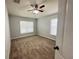 Bright, carpeted bedroom with natural light from two windows and a ceiling fan for comfort at 6768 Breezy Palm Dr, Riverview, FL 33578