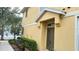 Charming yellow townhome exterior with a front door, lush landscaping, and well-maintained surroundings at 6768 Breezy Palm Dr, Riverview, FL 33578