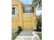 A charming yellow townhome with two garage doors, tasteful landscaping, and a cozy balcony on the second floor at 6768 Breezy Palm Dr, Riverview, FL 33578