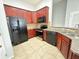 Well-equipped kitchen with dark cabinets, modern appliances, and tile flooring for a clean and stylish look at 6768 Breezy Palm Dr, Riverview, FL 33578