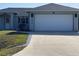 Charming single-story home featuring a two-car garage, lush lawn and mature landscaping at 7076 Nichols St, Englewood, FL 34224