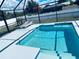 Beautiful screened-in pool area with lounge chairs and a spacious patio at 7076 Nichols St, Englewood, FL 34224