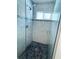 Modern walk-in shower with stone floor, glass door, and tiled walls at 7076 Nichols St, Englewood, FL 34224