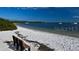 Relaxing beach view featuring a wooden bench, white sand, and sailboats on the water at 7912 Desoto Memorial Hwy, Bradenton, FL 34209