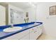 Bright bathroom with a double sink vanity, blue countertop, and shower with white tiled walls at 9142 16Th Avenue Nw Cir, Bradenton, FL 34209