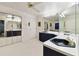 Bathroom featuring large mirrors, blue vanity, patterned wallpaper, and ample counter space at 9142 16Th Avenue Nw Cir, Bradenton, FL 34209