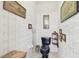 This powder room features patterned wallpaper, wall art, and dark blue toilet at 9142 16Th Avenue Nw Cir, Bradenton, FL 34209