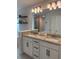 Bathroom featuring dual sinks, granite countertops, and a large mirror at 2556 Averland Loop, North Port, FL 34287
