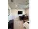 Bedroom with light colored walls, ceiling fan, and dark wood desk facing a TV mounted on the wall at 2556 Averland Loop, North Port, FL 34287
