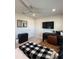 Bedroom with light colored walls, ceiling fan, and dark wood desk facing a TV mounted on the wall at 2556 Averland Loop, North Port, FL 34287