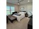Bedroom with natural light, light colored walls, and a bed with a rustic wood table at its foot at 2556 Averland Loop, North Port, FL 34287