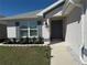 Inviting front entrance with gray front door, shutters, professional landscaping, and stone-lined flower beds at 2556 Averland Loop, North Port, FL 34287