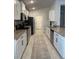 Contemporary kitchen featuring granite counters, stainless steel appliances, and white cabinets with black hardware at 2556 Averland Loop, North Port, FL 34287