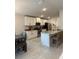 Bright kitchen with stainless steel appliances, granite countertops, and a breakfast bar with stool seating at 2556 Averland Loop, North Port, FL 34287