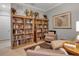Cozy living room featuring built-in bookshelves, comfortable seating, and wood flooring at 13303 Swiftwater Way, Lakewood Ranch, FL 34211