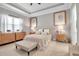 Spacious main bedroom with a tray ceiling, neutral tones, wood flooring, and decorative furnishings at 13303 Swiftwater Way, Lakewood Ranch, FL 34211