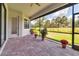 Screened-in patio featuring brick pavers, flower pots, and views of lush landscaping at 13303 Swiftwater Way, Lakewood Ranch, FL 34211