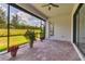 Screened-in patio featuring brick pavers, flower pots, and views of lush landscaping at 13303 Swiftwater Way, Lakewood Ranch, FL 34211