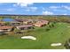 Expansive aerial shot of the neighborhood featuring a golf course, scenic lake, and beautiful homes at 13816 Messina Loop # 104, Bradenton, FL 34211