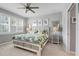 Inviting bedroom featuring a tropical-themed bedspread, a ceiling fan, and natural light from shuttered windows at 13816 Messina Loop # 104, Bradenton, FL 34211
