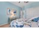 Comfortable blue bedroom featuring coastal decor, including art and matching floral bedding at 13816 Messina Loop # 104, Bradenton, FL 34211