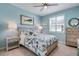 Coastal-themed bedroom with light blue walls, a ceiling fan, and natural light from the window at 13816 Messina Loop # 104, Bradenton, FL 34211