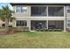 The exterior of the home with a screened-in patio and an expansive green lawn at 13816 Messina Loop # 104, Bradenton, FL 34211