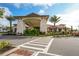 Stately community clubhouse entrance framed by lush landscaping and a grand porte-cochère at 13816 Messina Loop # 104, Bradenton, FL 34211