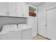 Efficient laundry room with white appliances, built-in cabinets and ample storage space at 13816 Messina Loop # 104, Bradenton, FL 34211