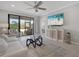 Bright living room with a ceiling fan, modern furniture, and sliding glass doors to an outdoor area at 13816 Messina Loop # 104, Bradenton, FL 34211