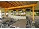 Open-air outdoor bar under a pergola with multiple TVs and seating at 13816 Messina Loop # 104, Bradenton, FL 34211