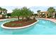 Resort-style pool with an island, lush landscaping, and lounge chairs at 13816 Messina Loop # 104, Bradenton, FL 34211