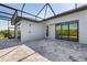 Enclosed patio area featuring gray pavers, sleek black frames, and sliding glass doors at 15170 Altura Rd, Port Charlotte, FL 33981