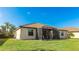 Backyard featuring a screened lanai, lush lawn, and a tile roof at 20170 Benissimo Dr, Venice, FL 34293