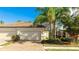 Two car garage and brick driveway with landscaping and beautiful blue skies at 20170 Benissimo Dr, Venice, FL 34293