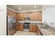 Stylish kitchen featuring stainless steel appliances, granite countertops, tile floor, and wood cabinets at 20170 Benissimo Dr, Venice, FL 34293