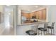Open kitchen area features a breakfast bar with granite countertops, stainless appliances, and tile flooring at 20170 Benissimo Dr, Venice, FL 34293
