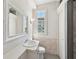 Bright bathroom featuring a large mirror, marble wainscoting, and a window at 210 N 17Th W St # 12, Bradenton, FL 34205