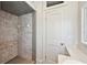 Bathroom showing a tiled shower, a built-in toiletry shelf, and a closed door at 210 N 17Th W St # 12, Bradenton, FL 34205