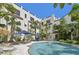 Beautiful pool area with lounge chairs, mature trees, and building views at 210 N 17Th W St # 12, Bradenton, FL 34205
