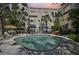 Beautiful community pool area with fountain, palm trees, lounge chairs, and sunset views at 210 N 17Th W St # 12, Bradenton, FL 34205