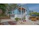 Back exterior view of charming blue house with garage, outdoor stairs and brick path and private backyard at 310 S Osprey Ave, Sarasota, FL 34236