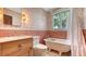 Bathroom featuring vintage clawfoot tub, pink tile accents, and stylish floral wallpaper at 310 S Osprey Ave, Sarasota, FL 34236