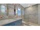 Bathroom featuring a glass-enclosed shower, floral wallpaper, and elegant blue vanity with marble countertop at 310 S Osprey Ave, Sarasota, FL 34236