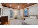 Bedroom with two twin beds, wood-planked ceiling, and a view of the enclosed porch at 310 S Osprey Ave, Sarasota, FL 34236