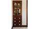 Antique wooden cabinet featuring glass doors with display shelving and lower drawers accented with classic hardware at 310 S Osprey Ave, Sarasota, FL 34236