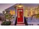 Quaint home featuring a bright red front door, complemented by neat landscaping and exterior lighting at 310 S Osprey Ave, Sarasota, FL 34236